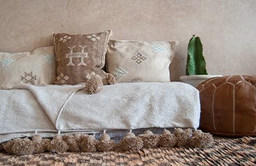 Cozy living room with cactus silk pillows and a Moroccan checker rug.